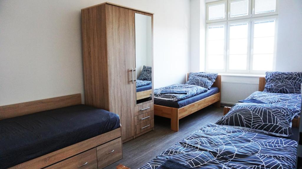 a bedroom with two beds and a dresser and a mirror at Apartment Hornický dům in Sokolov