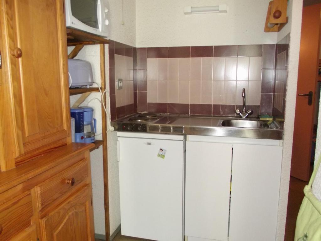 a small kitchen with white cabinets and a sink at les goutilles in Sainte-Marie-de-Campan