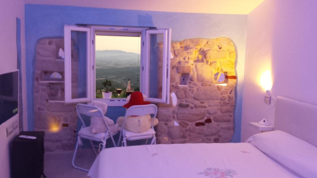 a bedroom with a bed and a window with a table and chairs at La casa degli specchi in Roccastrada