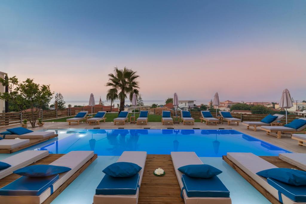 a pool with chaise lounge chairs and a resort at Venilia Apartments-4 in Zakynthos