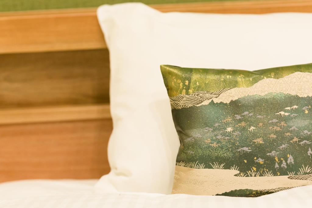 京都Stay SAKURA 京都 御苑东的床上的枕头