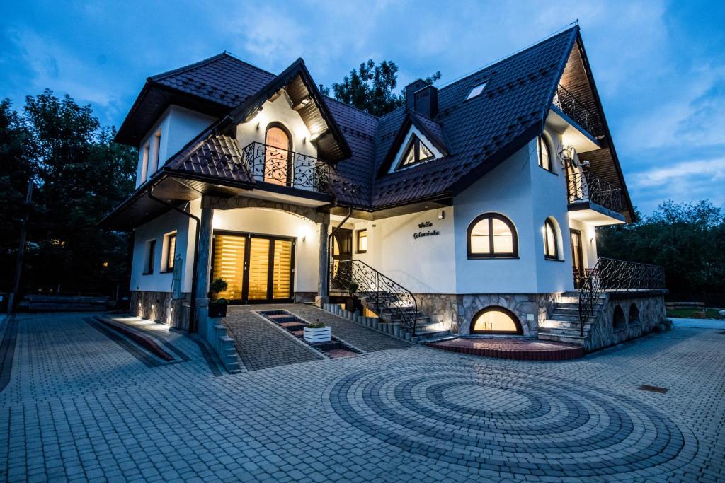 a large house with a brick driveway in front of it at WILLA GALANTÓWKA in Zakopane