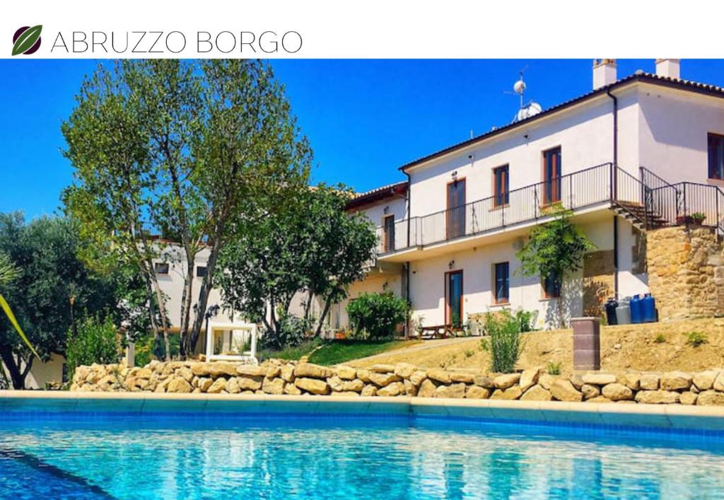 a villa with a swimming pool in front of a house at Abruzzo Borgo in Alanno