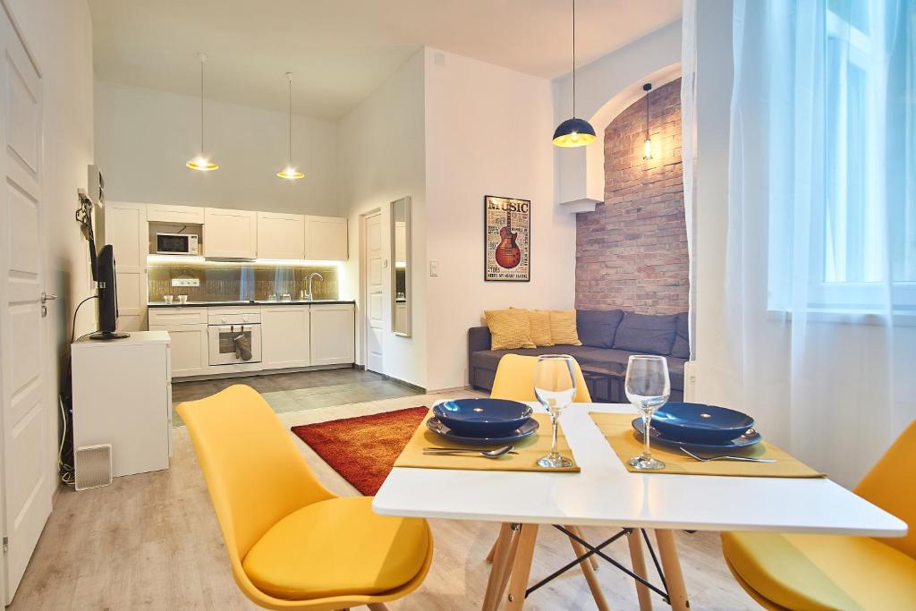 ブダペストにあるDesign Apartment in the City Center with ACのキッチン、リビングルーム(テーブル、黄色い椅子付)