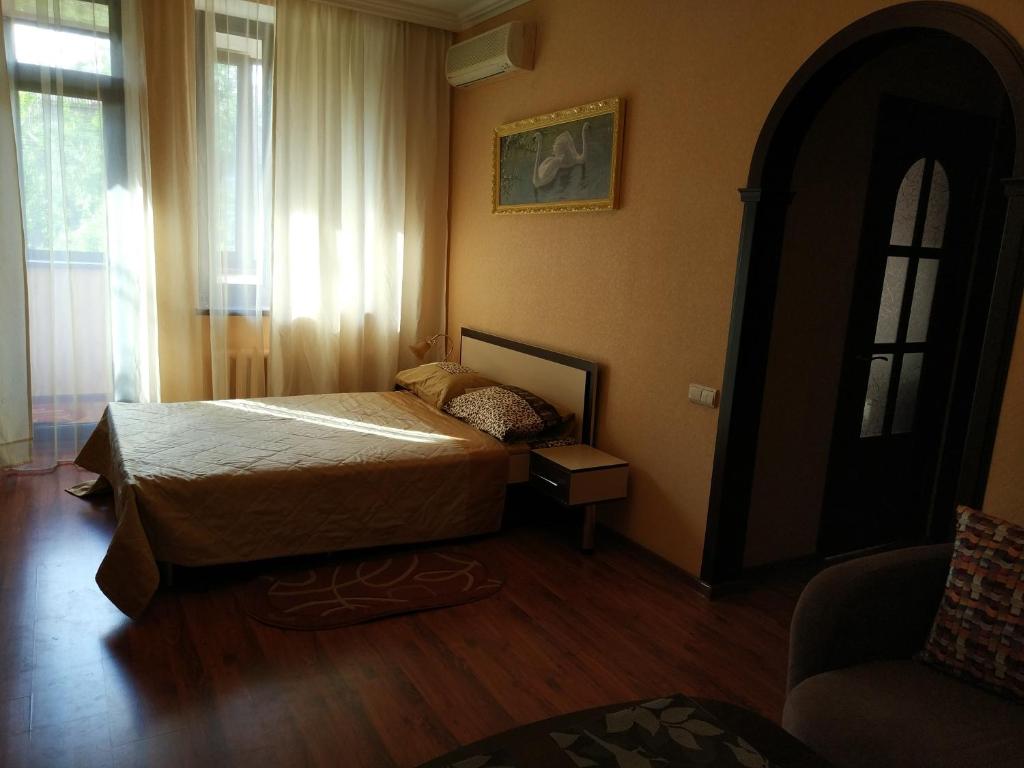 ザポリージャにあるApartment Lux Center Ukraina moll, near cafe Bosforのベッドルーム1室(ベッド1台、椅子、窓付)