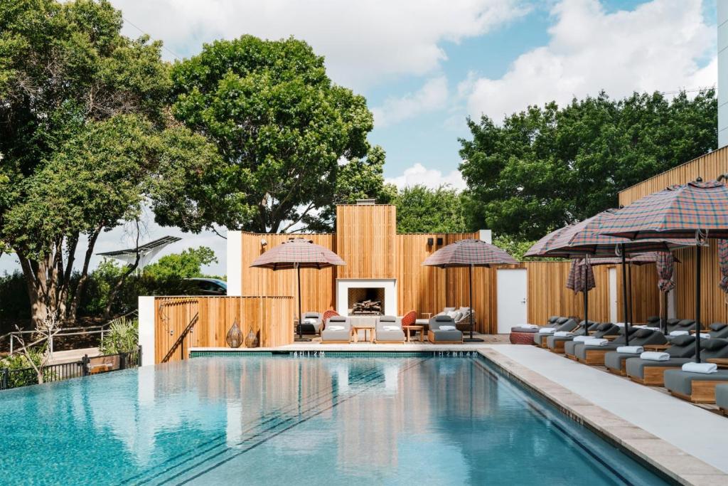 a swimming pool with lounge chairs and a fireplace at The LINE Austin in Austin