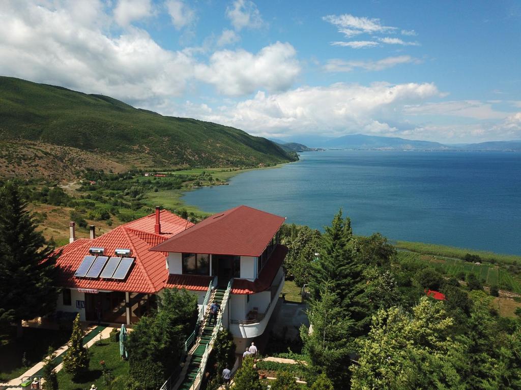 a house with a red roof and a view of the water at Hotel Camping Lin in Pogradec