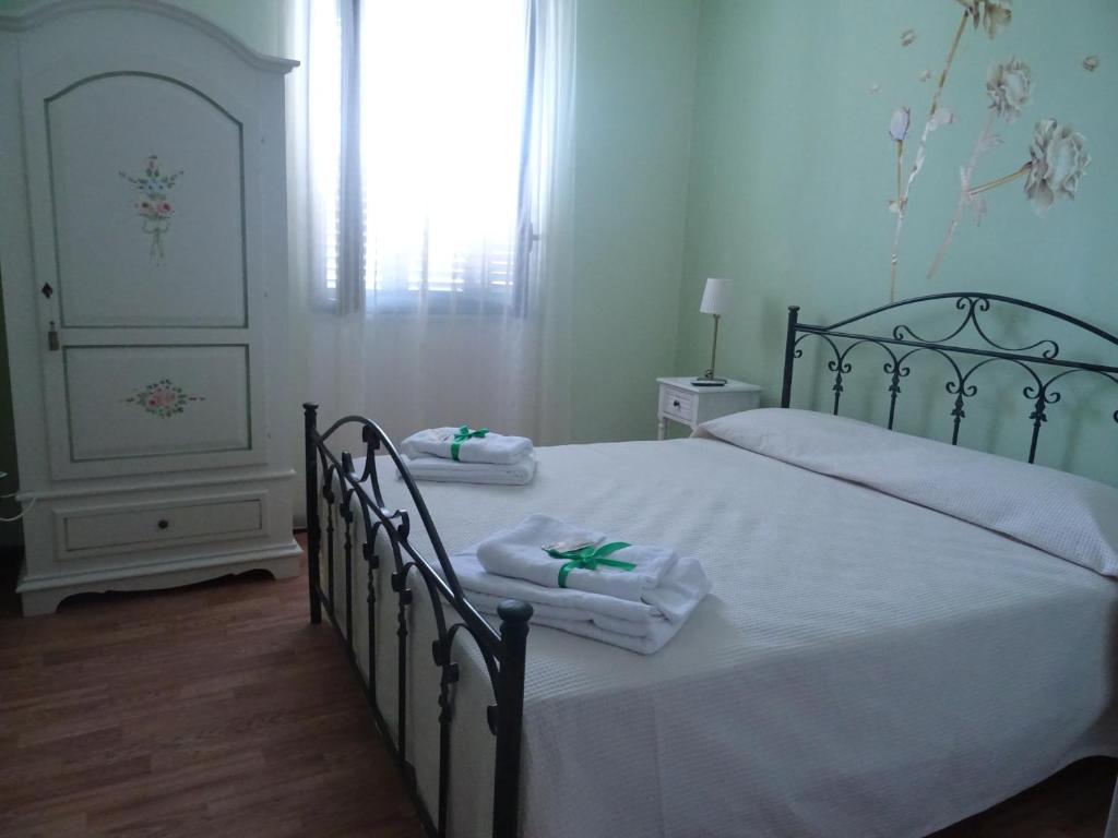 a bedroom with two beds with towels and a window at B&B Alòs in Sapri