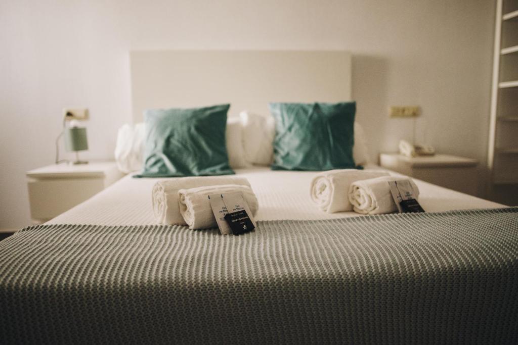 a bedroom with a large bed with green pillows at Hotel Nuro in Barbate