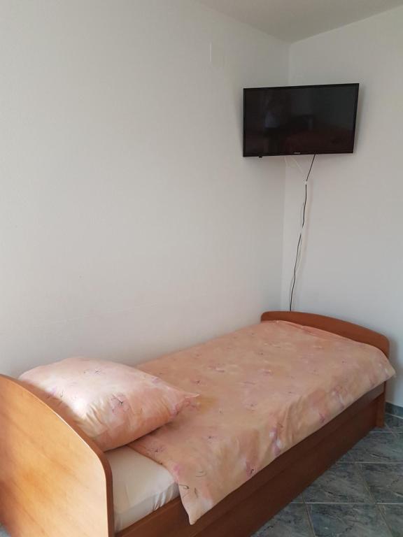 sypialnia z łóżkiem i telewizorem z płaskim ekranem na ścianie w obiekcie Apartman Edin w mieście Umag