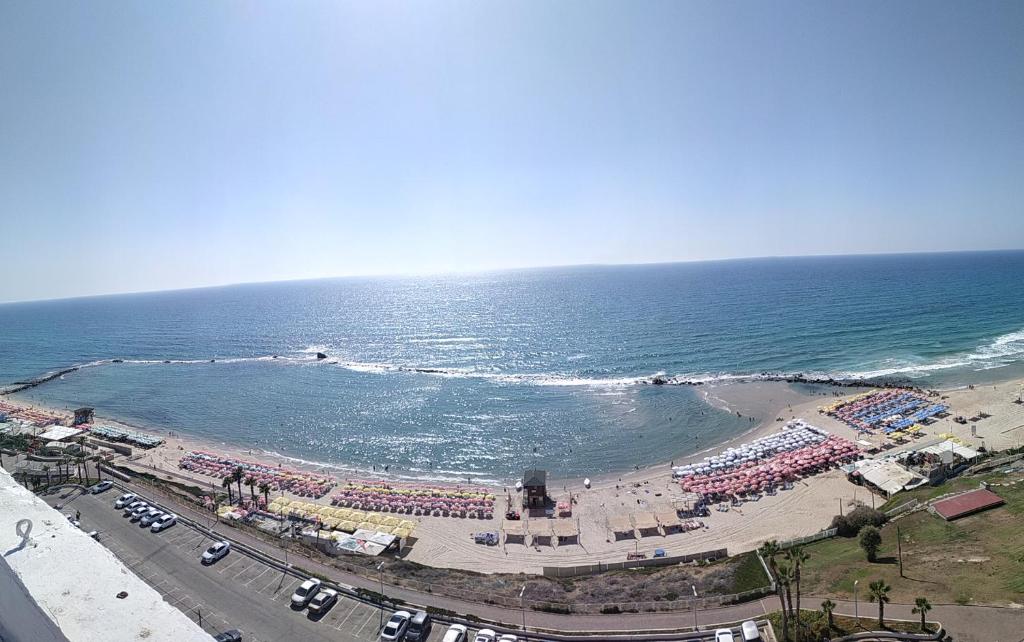 una spiaggia con una folla di persone e l'oceano di Sweet Honeymoon Apartment Tel Aviv Bat Yam 611 a Bat Yam