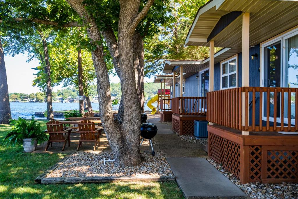 a house with a tree and a table and chairs at Point View Resort in Camdenton