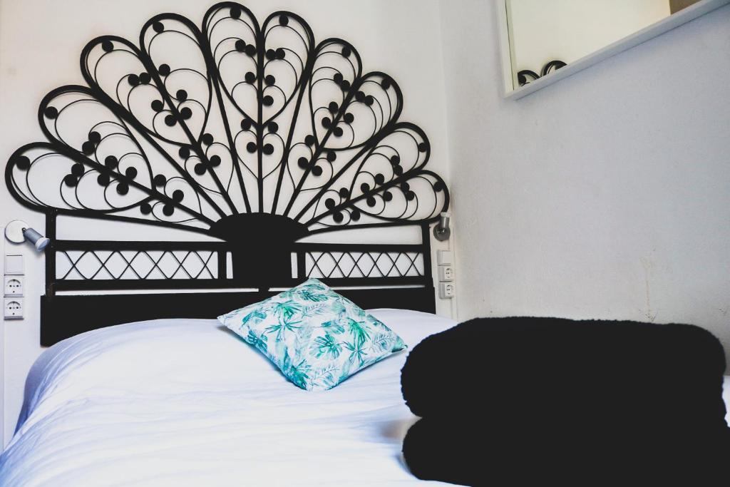 a black headboard with a pillow on a bed at Beach House São Pedro in São Pedro do Estoril