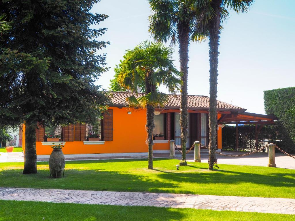 un edificio de naranjos con palmeras delante de él en La Brigata Apartments Orange House, en Cavallino-Treporti