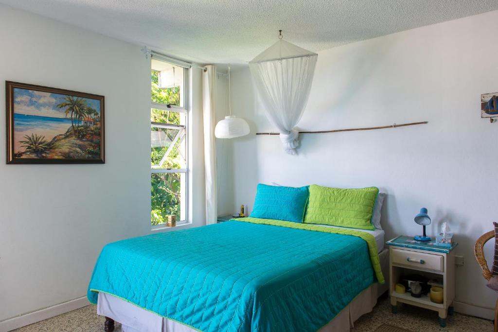 a bedroom with a blue bed and a window at Deluxe Montego Bay Club Studio & Suites in Montego Bay