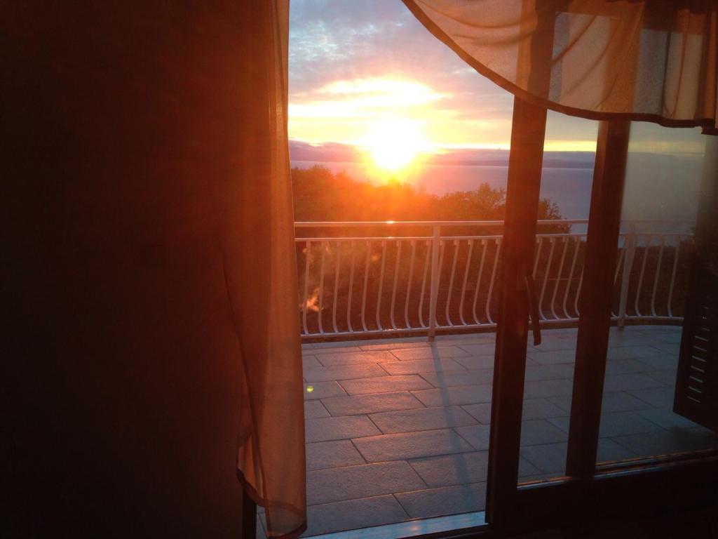 a view of the sunset from a balcony at Spacious Apartment in quiet surrounding in Ičići