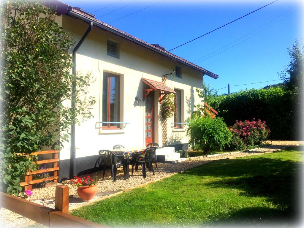 una casa bianca con tavolo e sedie nel cortile di Saint Moreil Gite a Saint-Moreil