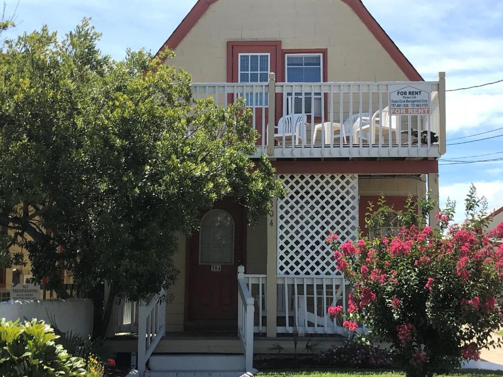 une maison dotée d'un balcon avec des chaises. dans l'établissement Angie's Guest Cottage, à Virginia Beach