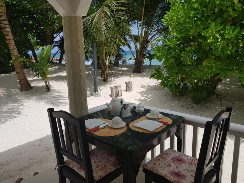 a table with a plate of food on the beach at Villa Admiral in Anse Possession