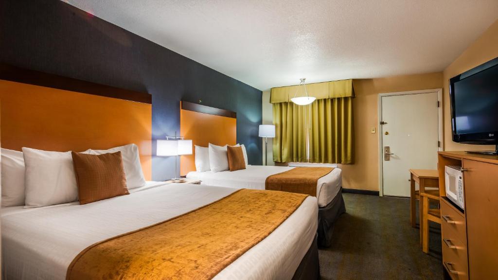 a hotel room with two beds and a flat screen tv at Best Western Horizon Inn in Medford
