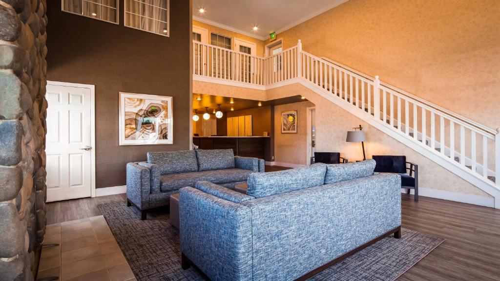a living room with two couches and a staircase at Best Western Horizon Inn in Medford