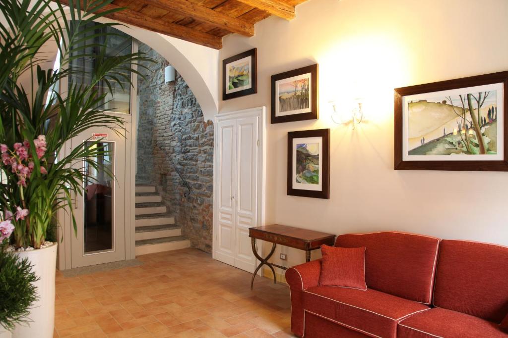 فندق بورغو أنتيكو في كومو: غرفة معيشة مع أريكة حمراء ودرج
