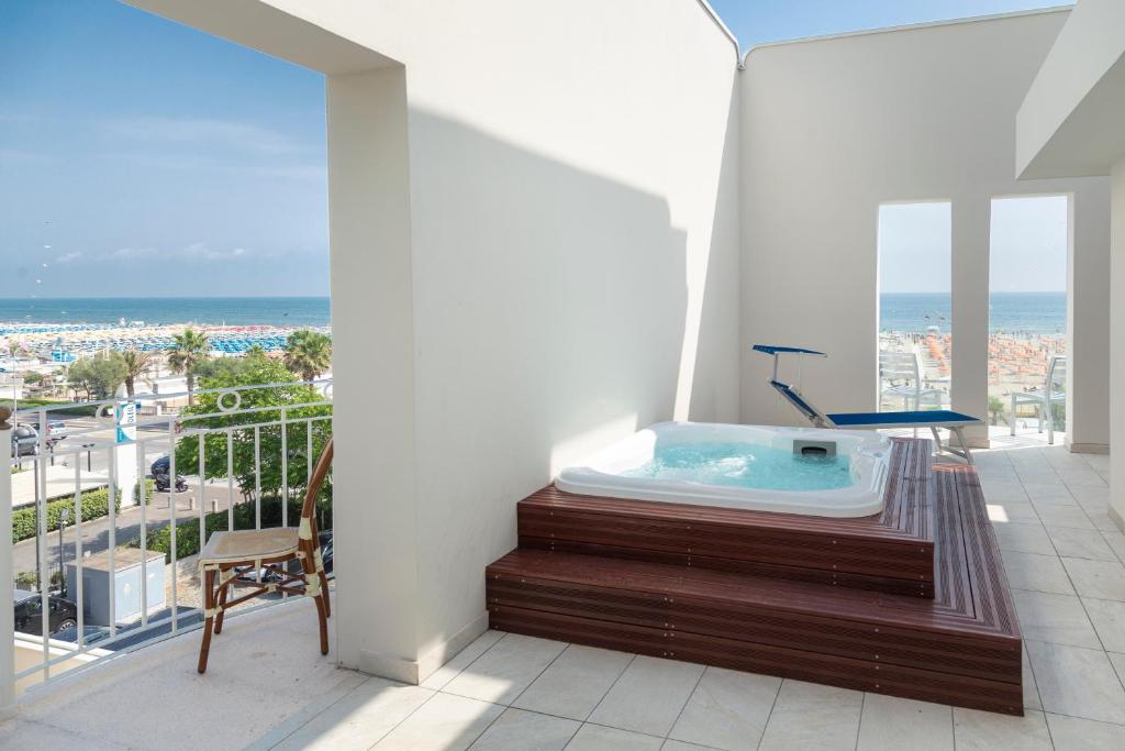 a bathroom with a jacuzzi tub on a balcony at Hotel Ambassador in Rimini
