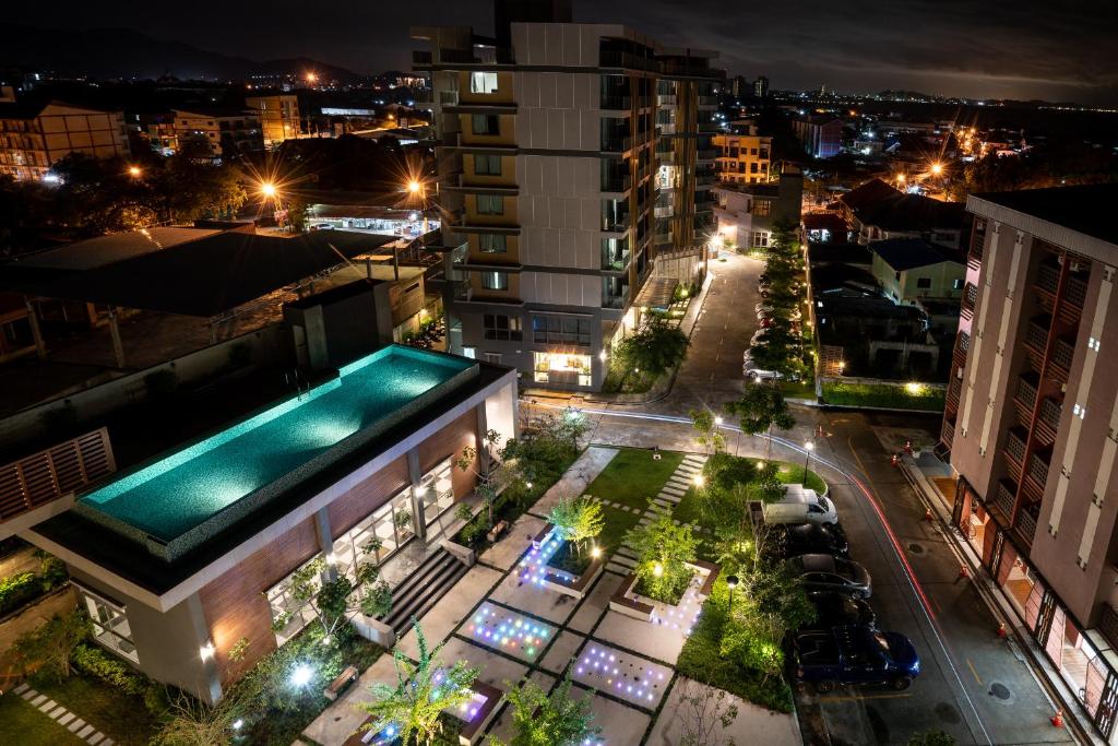 a view of a city at night with a swimming pool at ONPA Hotel & Residence Bangsaen in Bangsaen