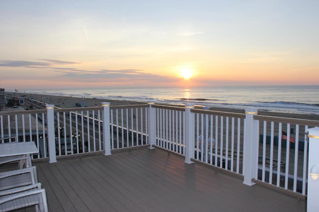 a balcony with a view of the ocean at sunset at Safari Hotel Boardwalk in Ocean City