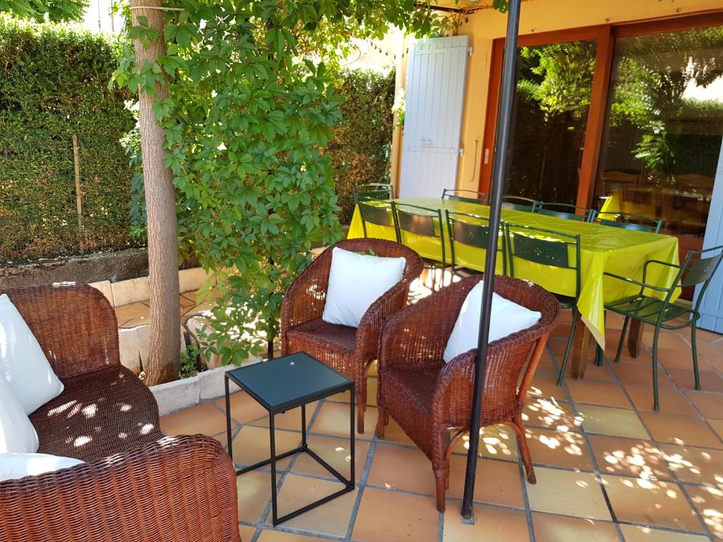 un groupe de chaises et une table sur une terrasse dans l'établissement Maison les Salles-sur-Verdon, aux Salles-sur-Verdon