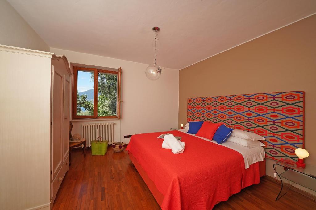 ein Schlafzimmer mit einem roten Bett mit einer roten Decke in der Unterkunft Anna Torri in Torri del Benaco