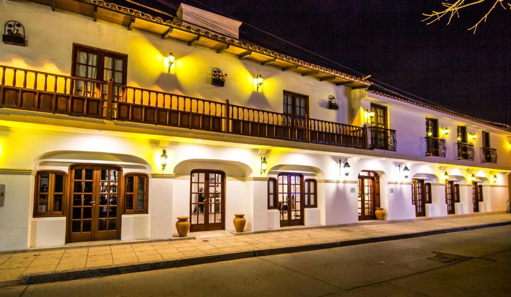 - un bâtiment blanc avec un balcon dans une rue dans l'établissement Hotel Asturias, à Cafayate