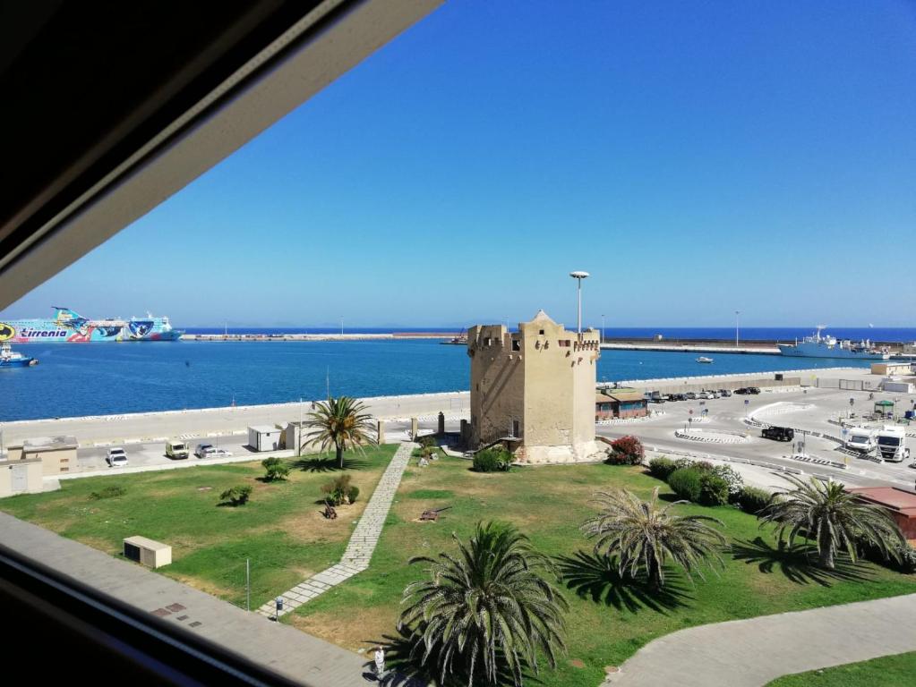 einen Blick aus einem Fenster eines Gebäudes neben dem Meer in der Unterkunft Attico "Elisa" Vista Mare in Porto Torres