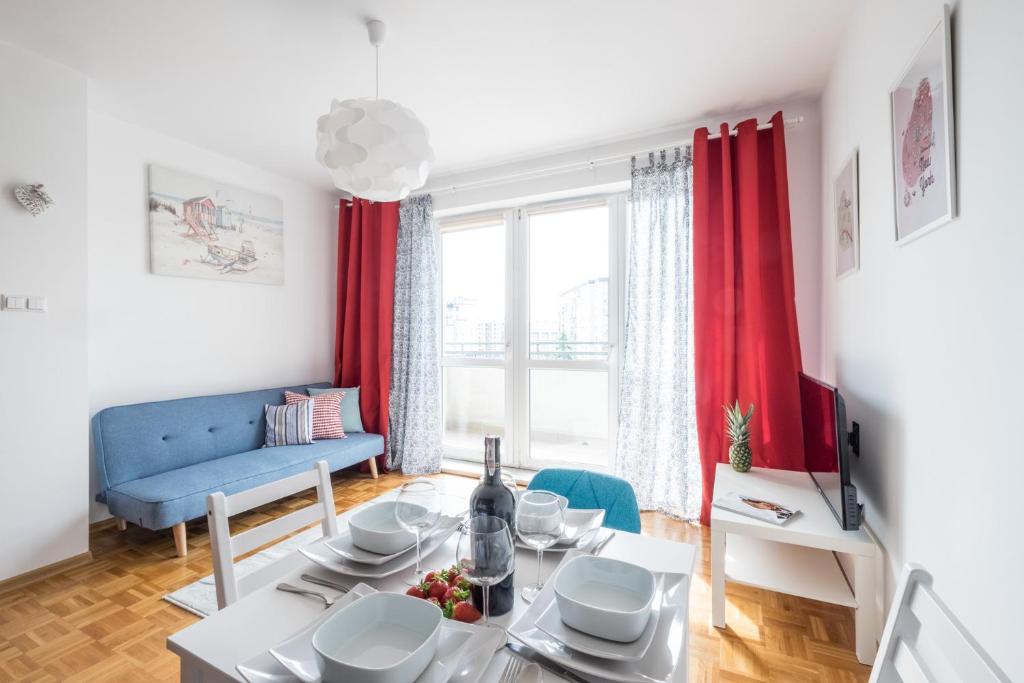 a living room with a table and a blue couch at Blue Sky Apartment Warsaw in Warsaw