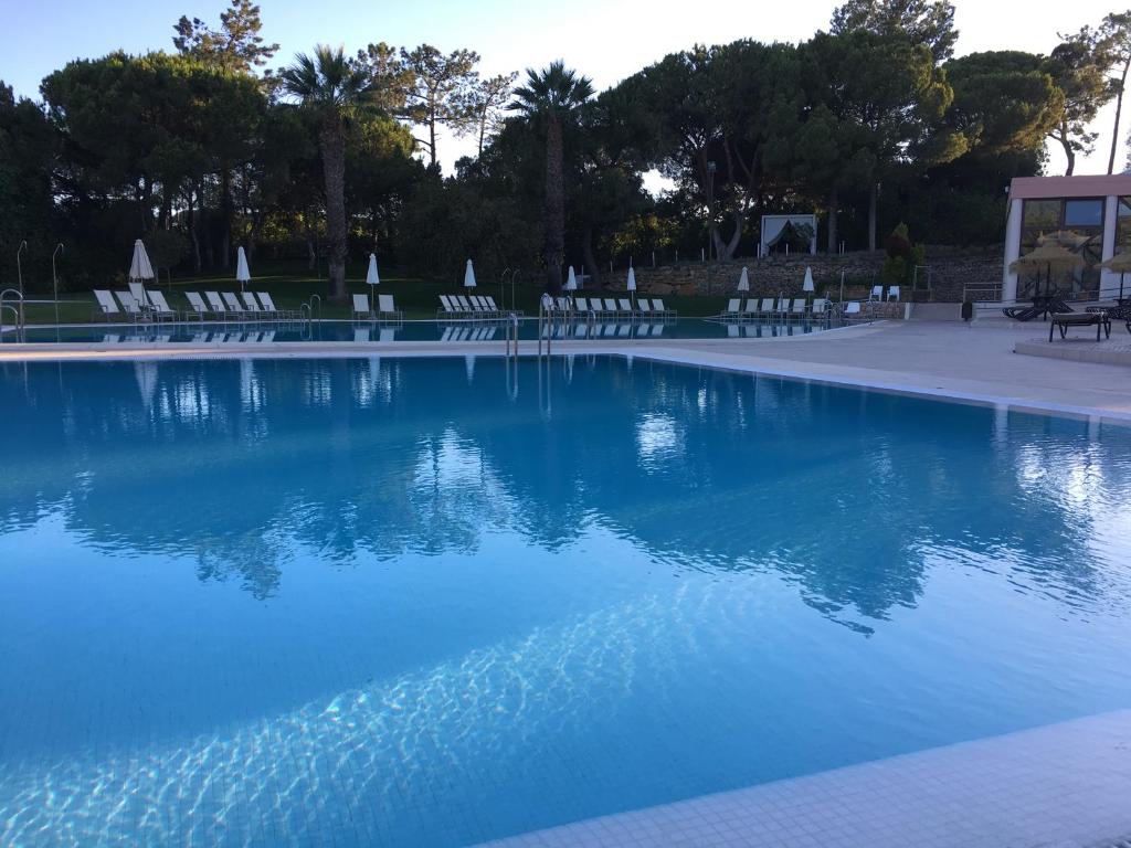 a swimming pool with chairs and blue water at Quinta do Lago Golf in Quinta do Lago