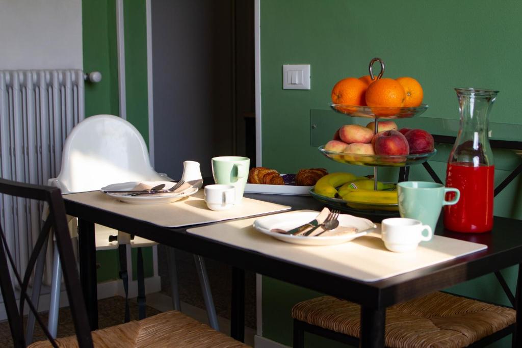 une table avec des assiettes et des bols de fruits dans l'établissement La bicicletta Rossa B&B, à Cenaia