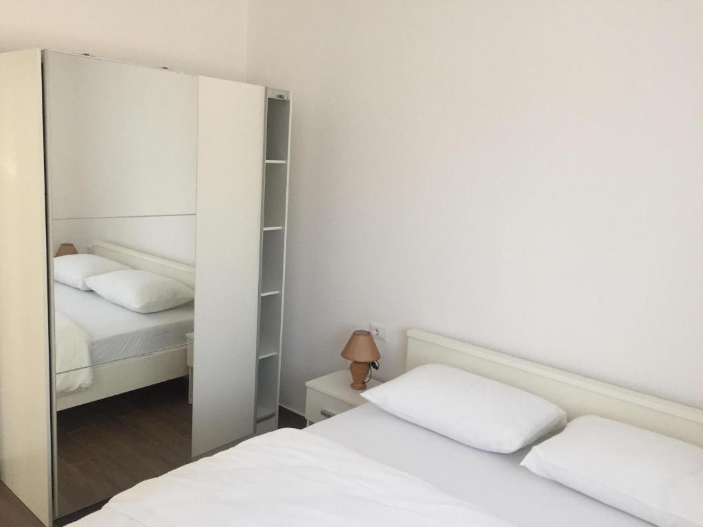 a bedroom with two beds and a mirror at Bakovic in Funtana