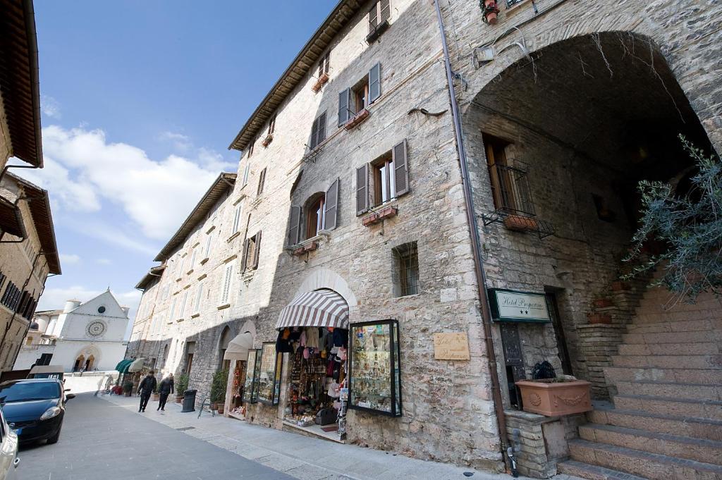 - un vieux bâtiment en pierre sur le côté d'une rue dans l'établissement Hotel Properzio, à Assise