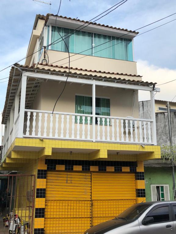 a house with a yellow door in front of it at Kitnet Central in Arraial do Cabo