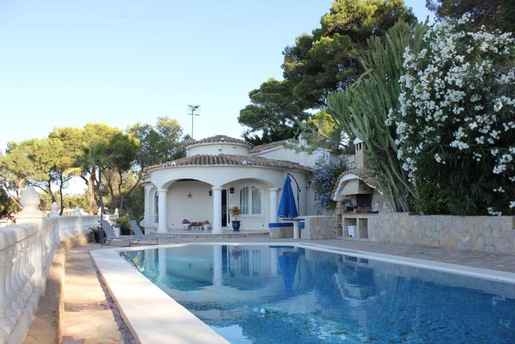 una casa con piscina frente a ella en El Nido, en Denia