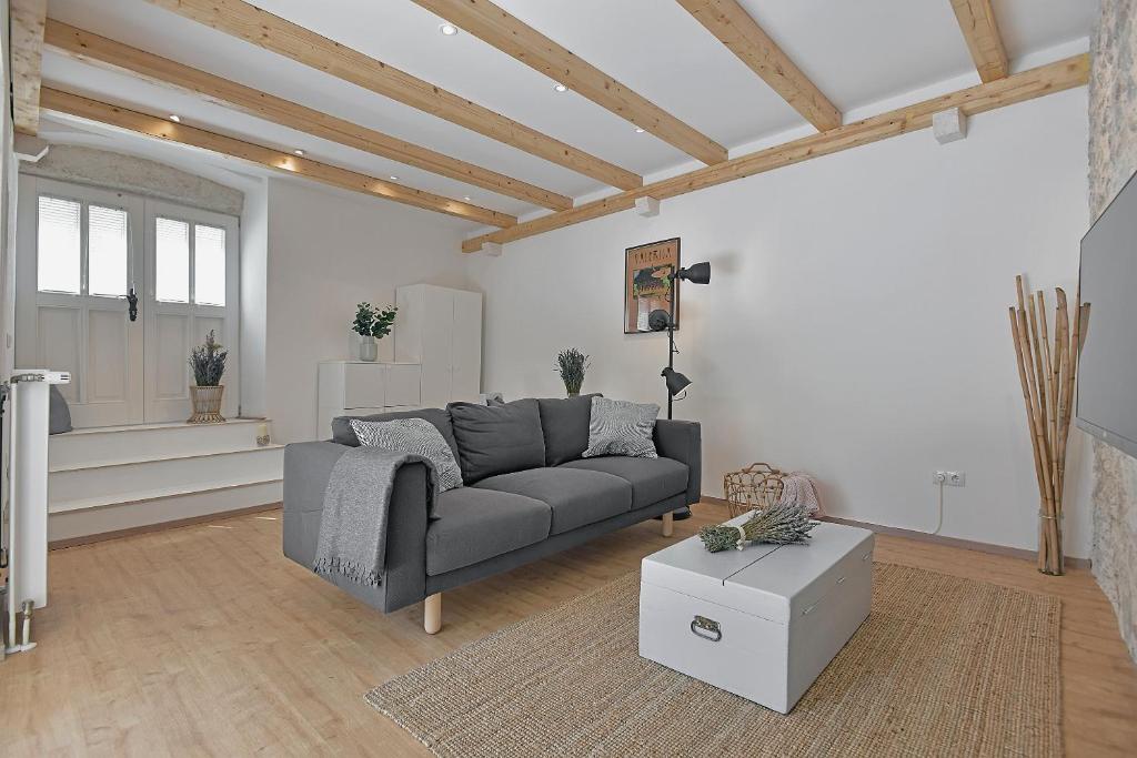 a living room with a gray couch and a table at Pupi's Heritage in Hvar