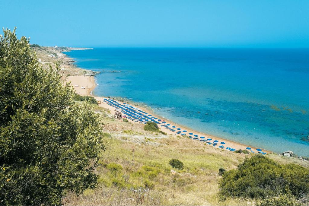 una playa con un montón de sombrillas y el océano en Villaggio L'Oasi, en Isola di Capo Rizzuto