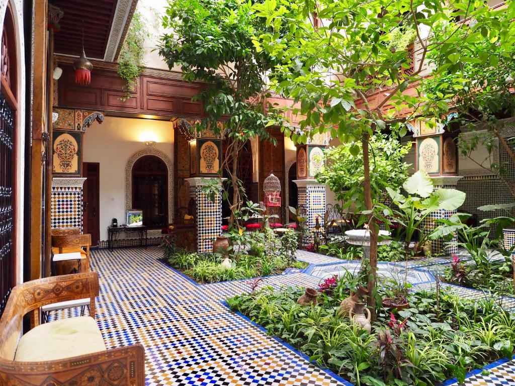 a courtyard with a garden with trees and plants at Riad Toyour- Riad of birds in F&egrave;s
