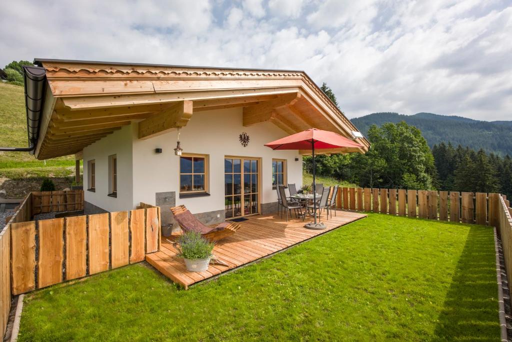 una piccola casa con terrazza e ombrellone di Reiterbauer Chalets & Ferienwohnungen a Kirchberg in Tirol