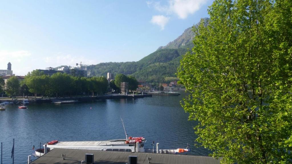 uma vista para um rio com um barco em Casa al Lago em Lecco