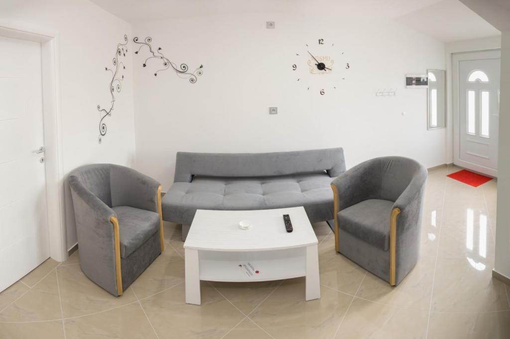 a living room with two chairs and a couch and a table at Apartmani "ROSHU" in Soko Banja