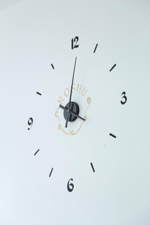 a clock on a white wall at Apartmani "ROSHU" in Soko Banja