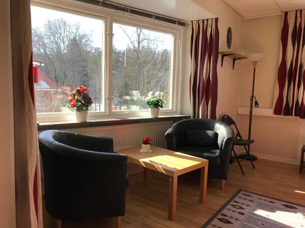 sala de estar con sillas, mesa y ventana en Hågadalens Hostel & Vandrarhem, en Uppsala