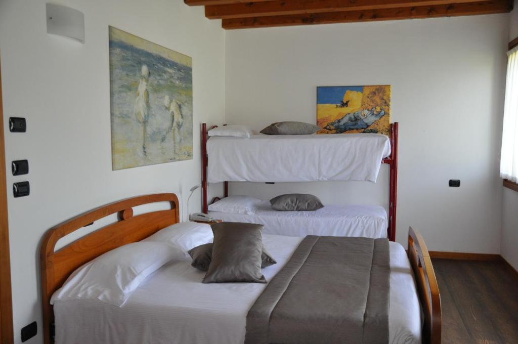 2 łóżka w pokoju z 2 łóżkami piętrowymi w obiekcie Agriturismo Ancillotto w mieście Meolo