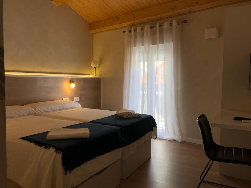 プラセンシアにあるCasita del Abuelo Mayorgaのベッドルーム1室(ベッド1台、バスタブ、窓付)